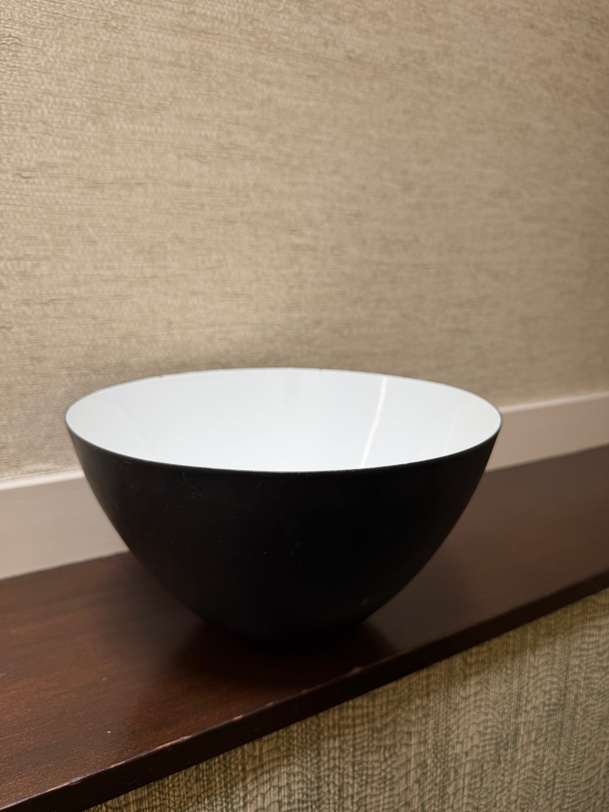 Close-up of a black and white cylindrical bowl on a textured surface