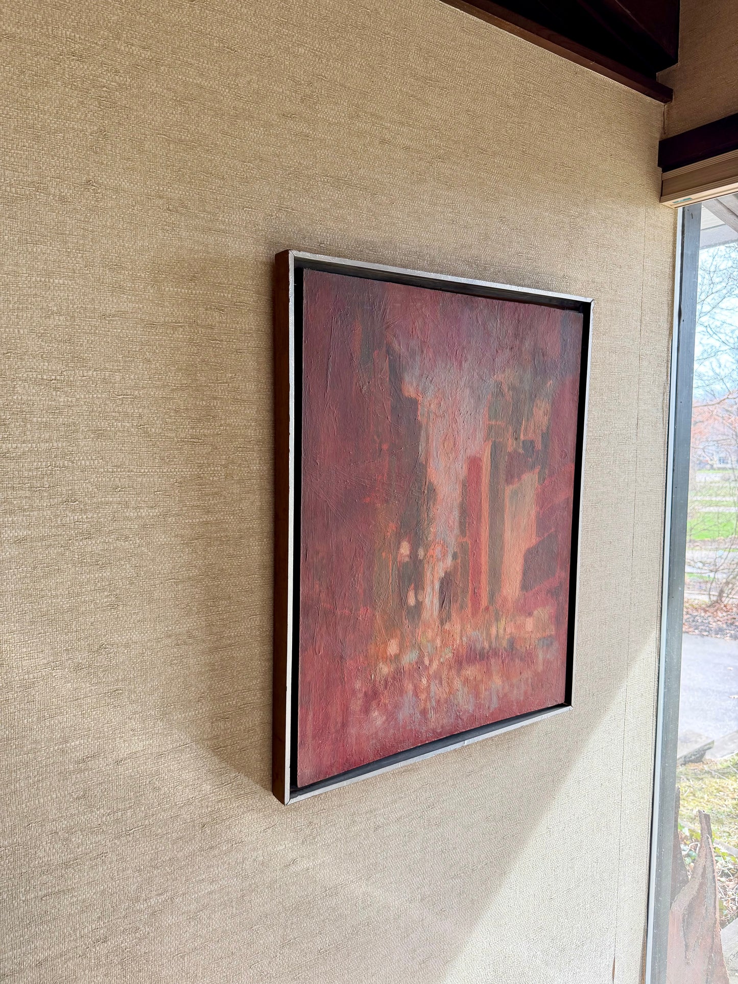 Framed abstract painting on a textured wall