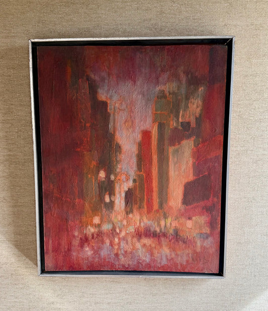 Framed abstract painting with warm tones on a textured wall.