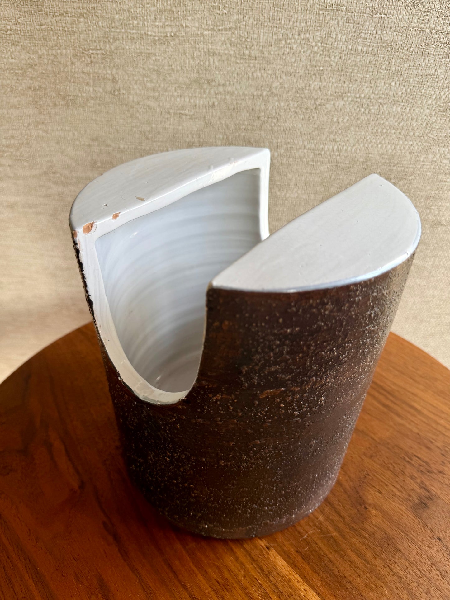 Cylindrical container with a white lid on a wooden surface
