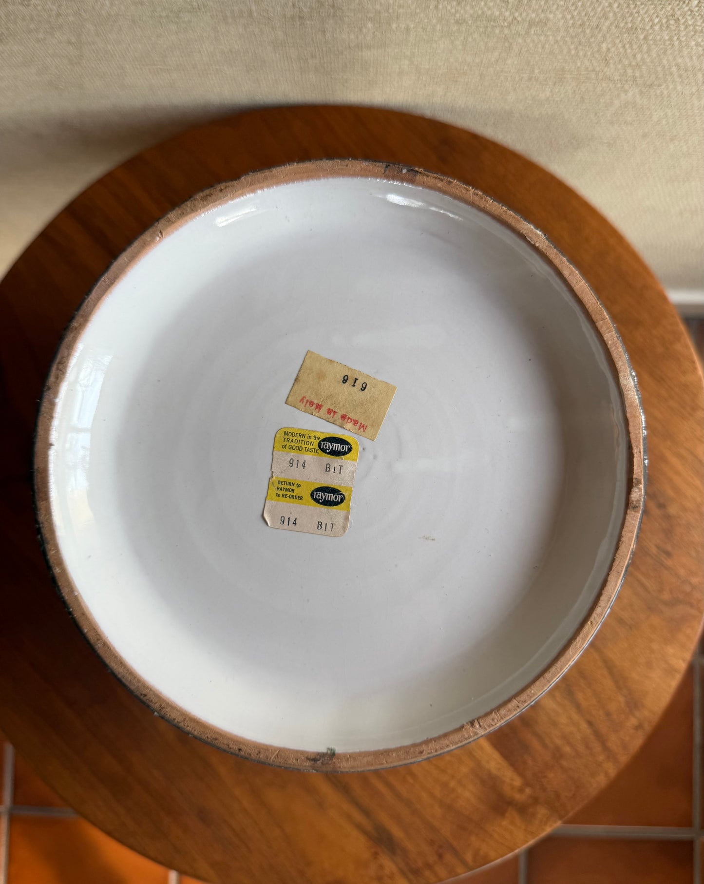 White ceramic plate with labels on a wooden stand