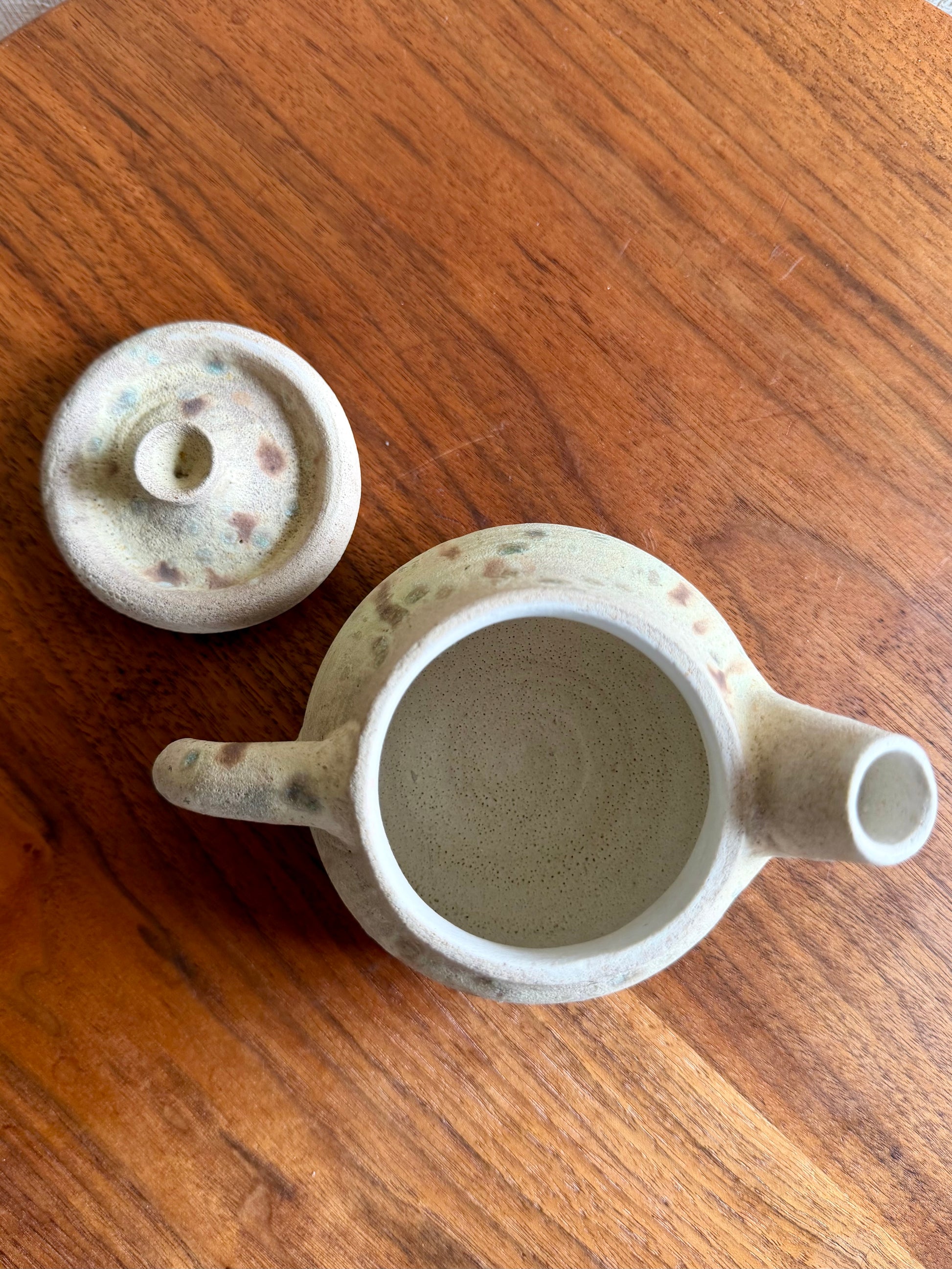 Ceramic teapot and lid on a wooden surface