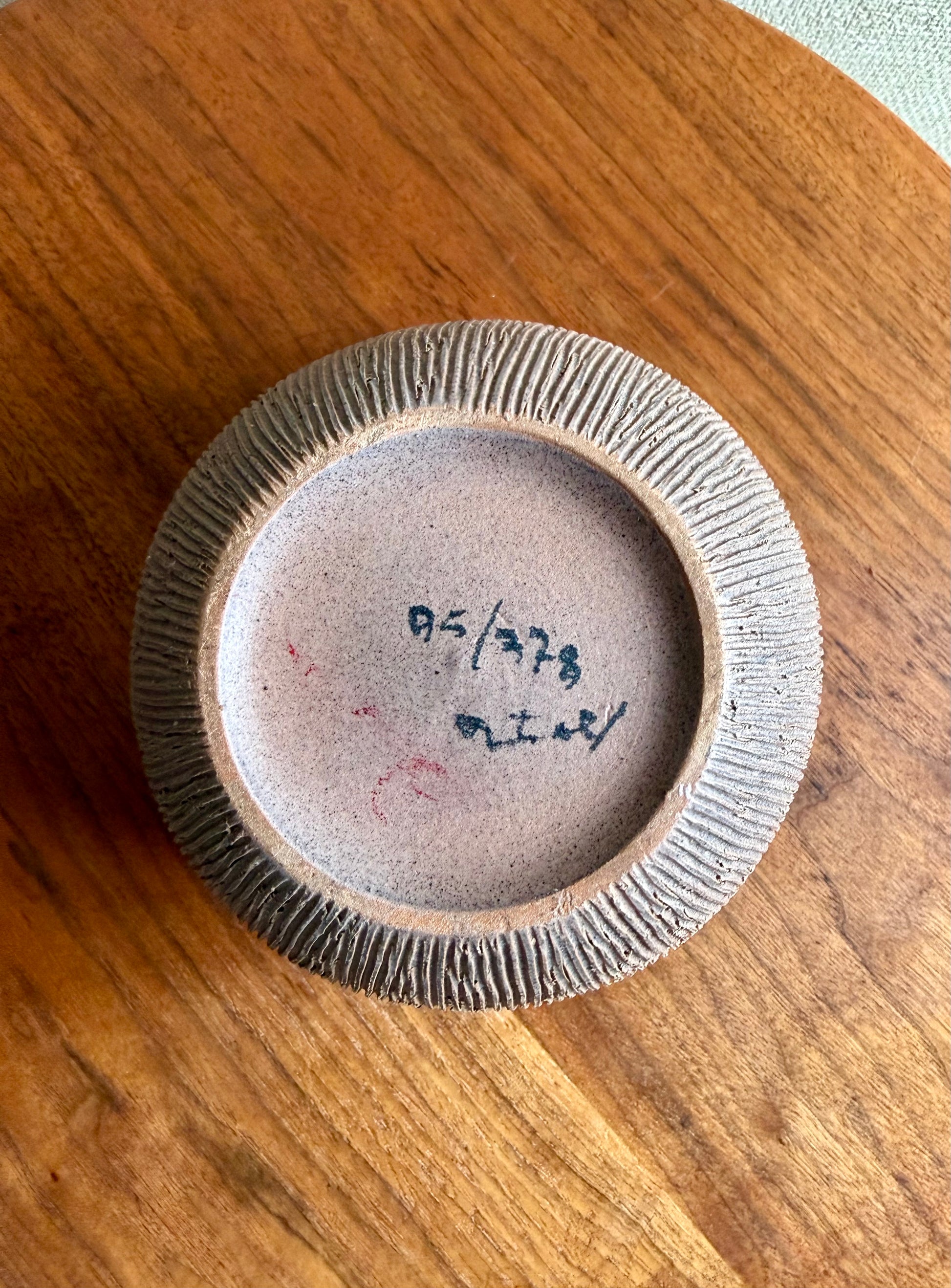 Small ceramic bowl with textured rim on a wooden surface