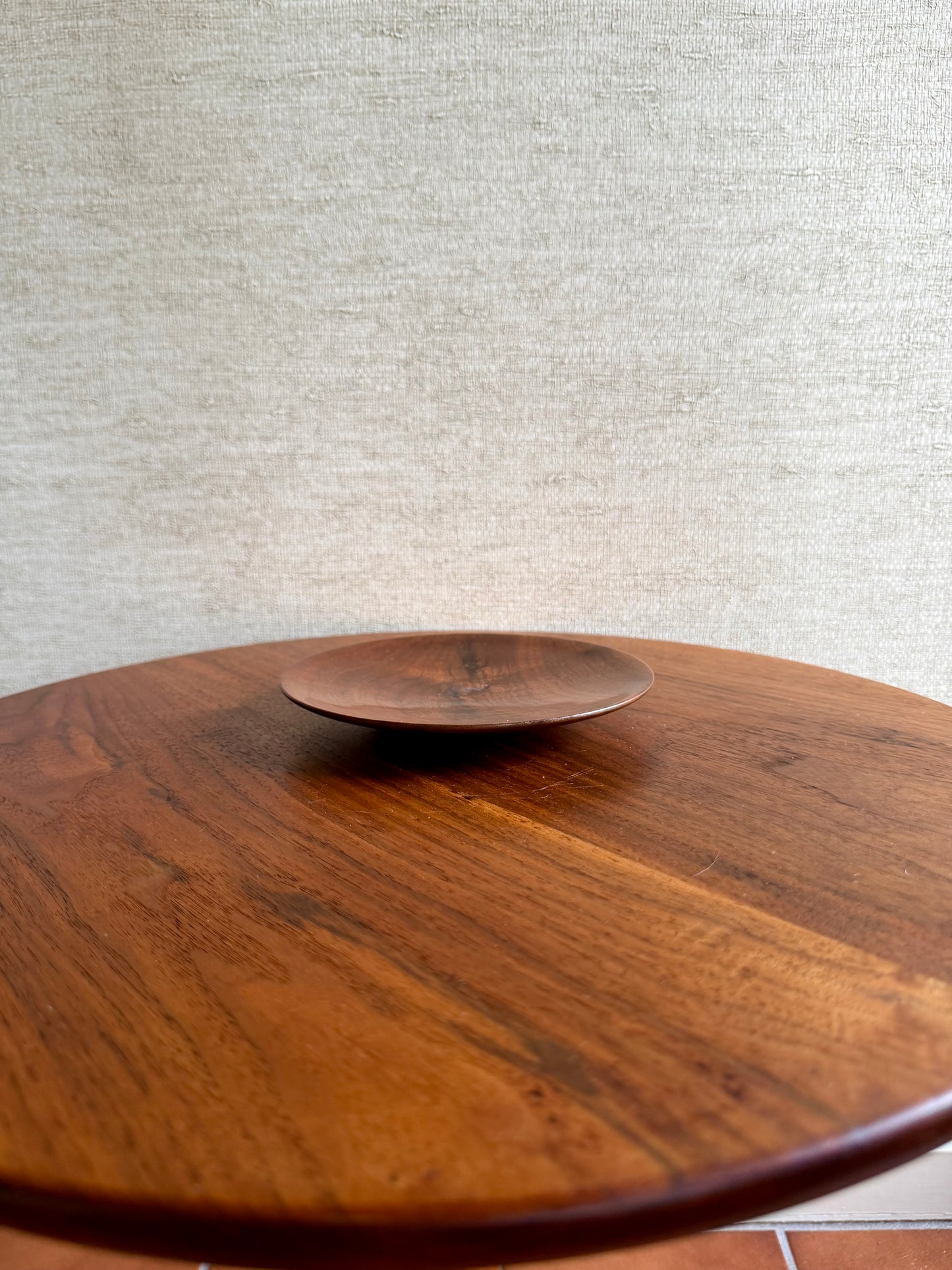 Wooden table with a metallic object on a textured gray background