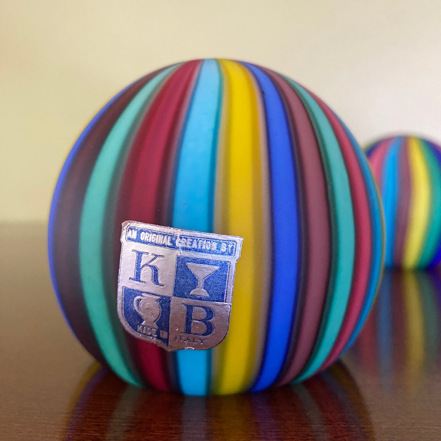 Colorful striped ball with a logo on a reflective surface