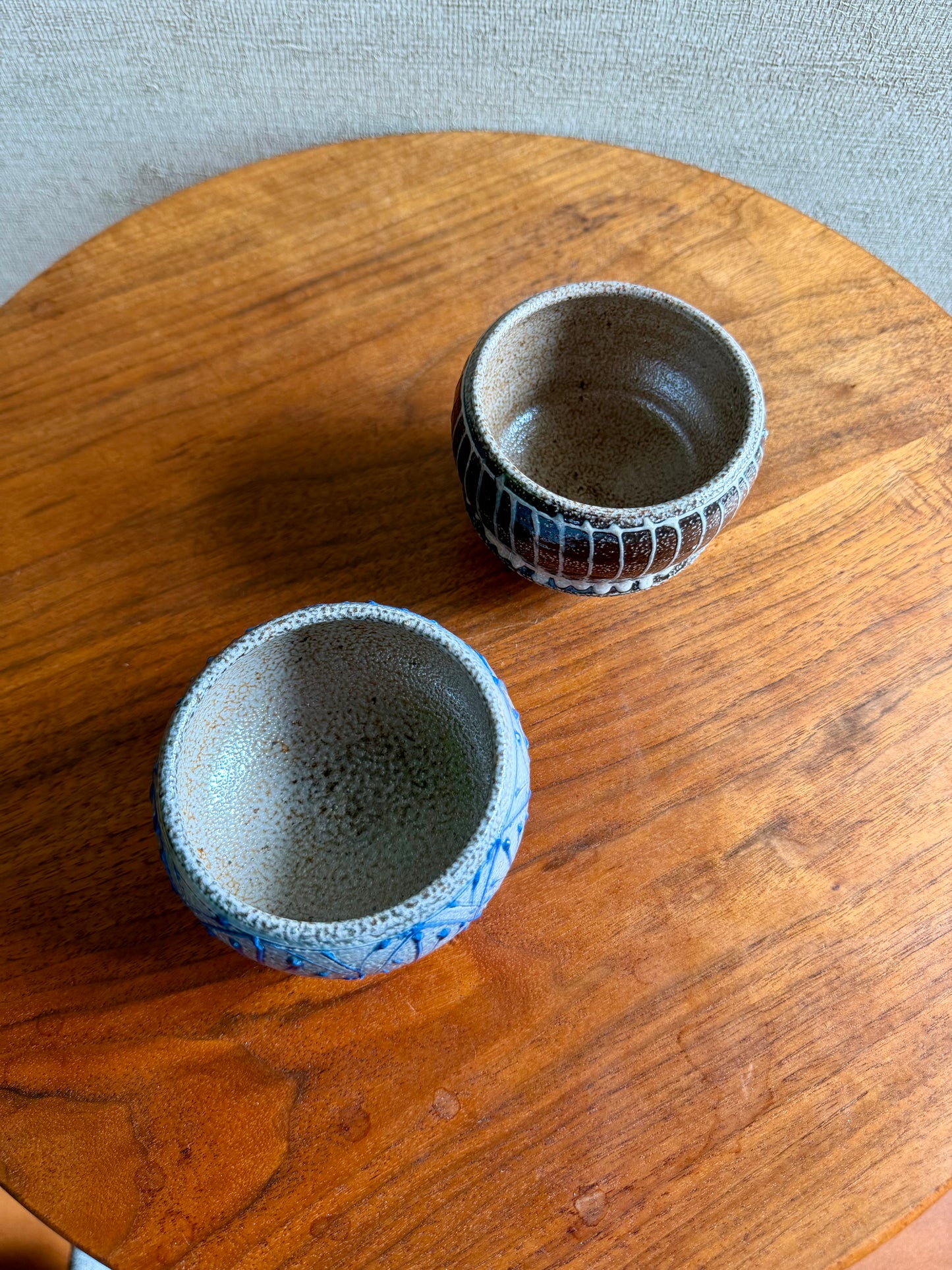 Two ceramic bowls on a wooden surface with a neutral background