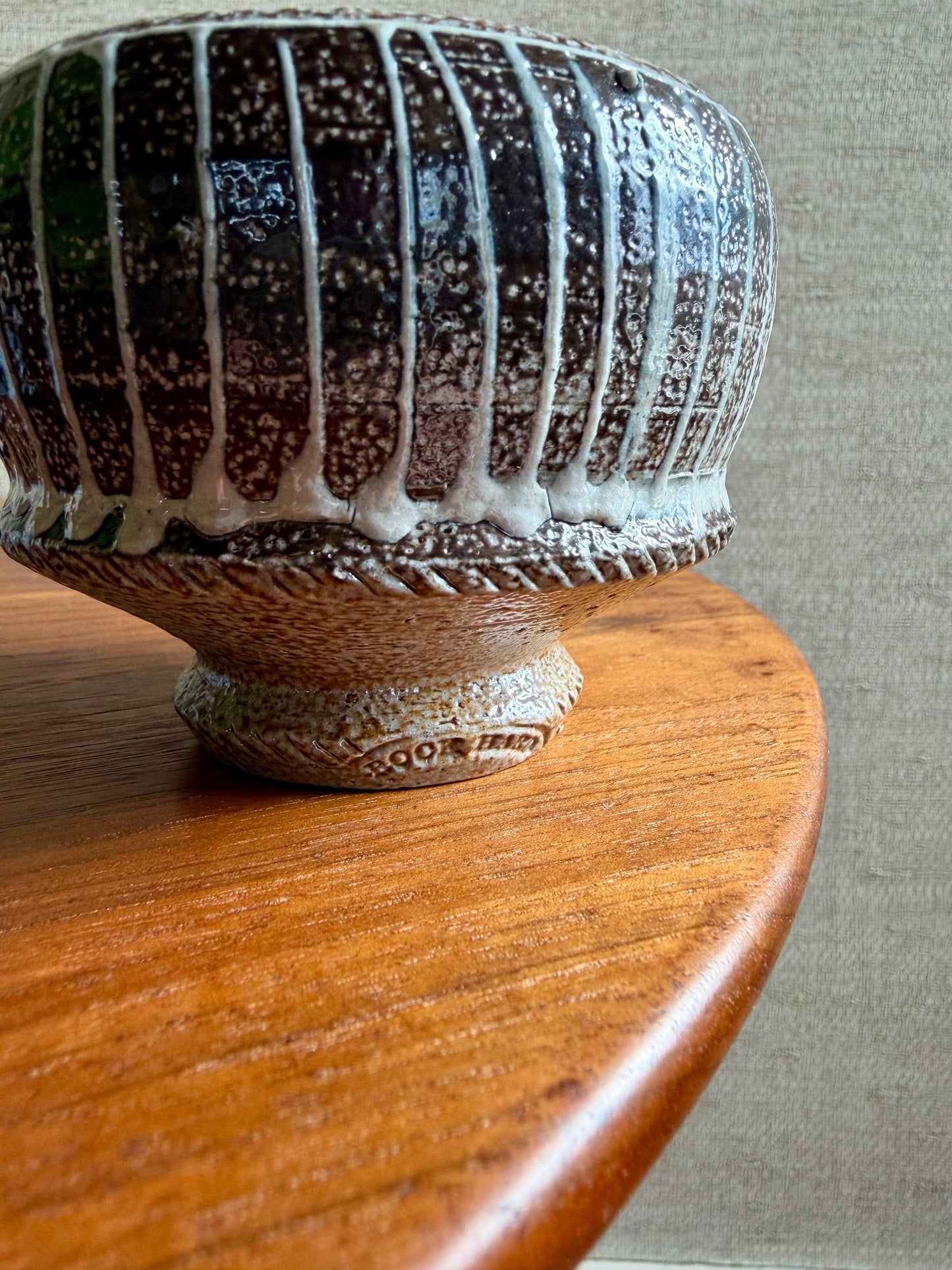 Ceramic vase with textured surface on a wooden surface