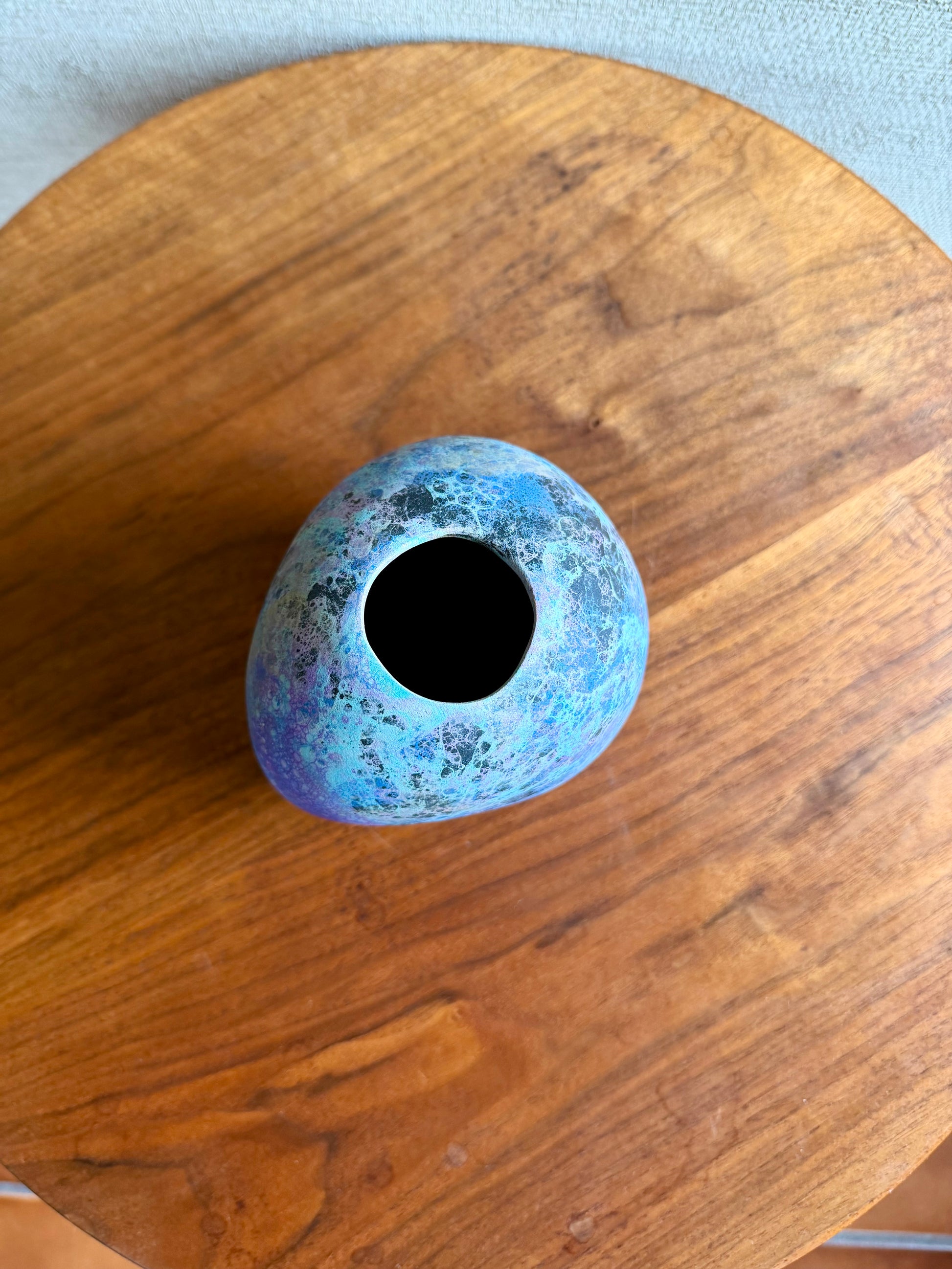 Blue ceramic vase on a wooden surface