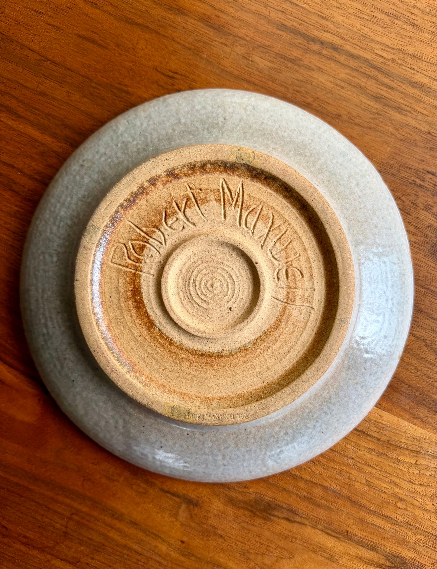 Ceramic plate with a visible brand logo on a wooden surface