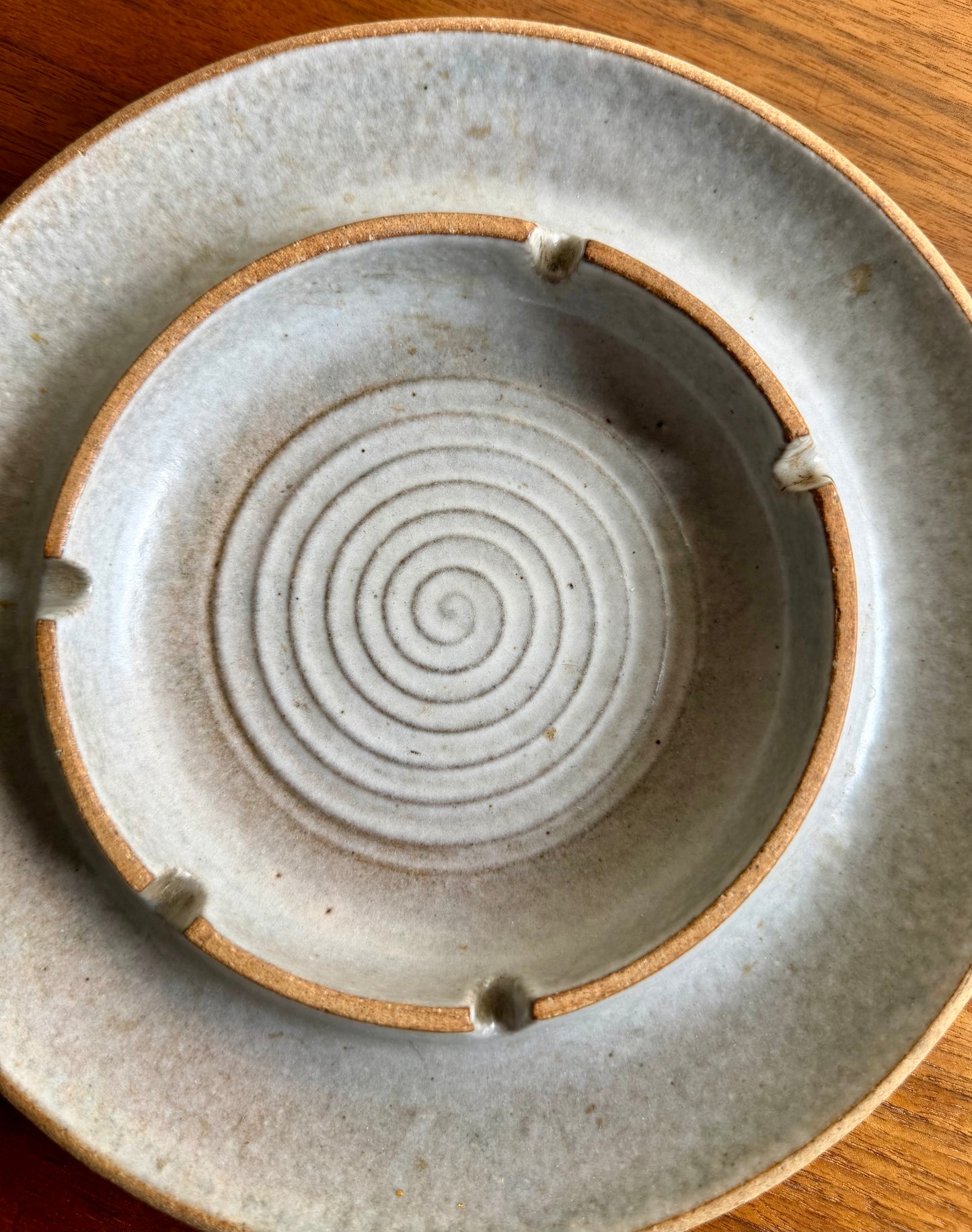 Ceramic plate with concentric circle design on a wooden surface