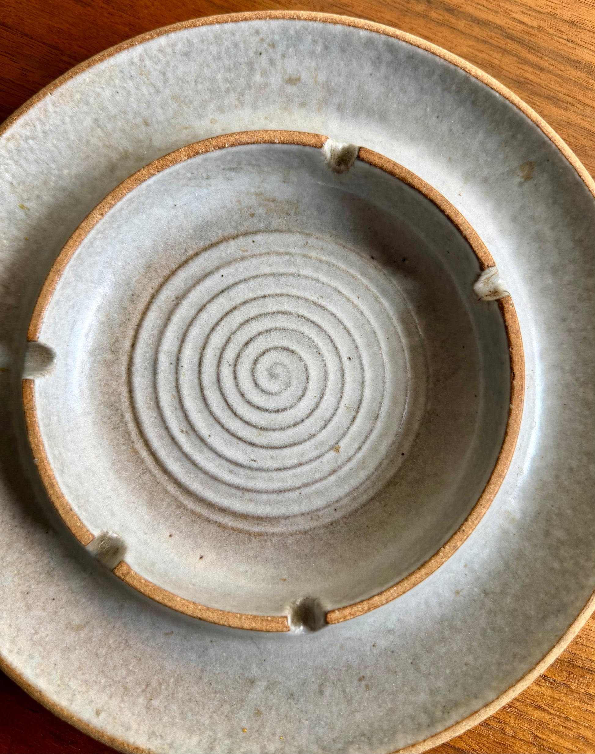 Ceramic plate with concentric circle design on a wooden surface