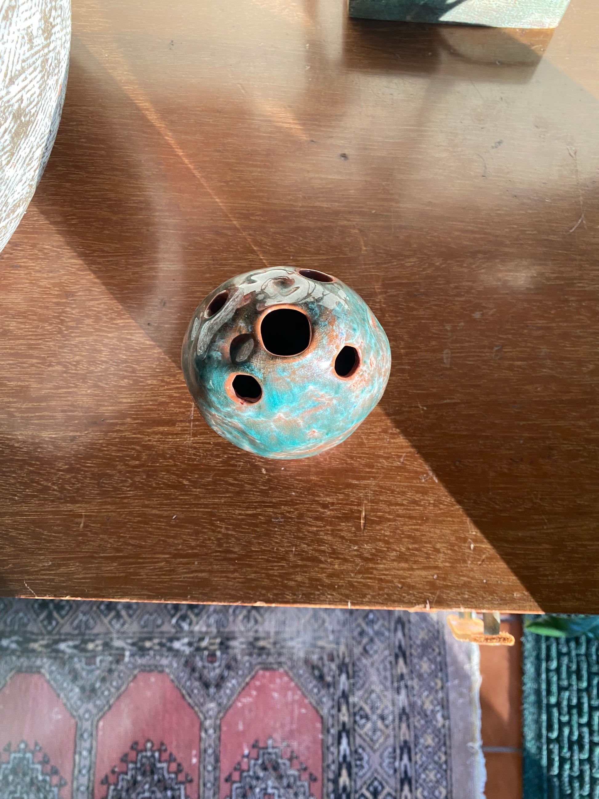Decorative ceramic vase with a textured surface on a wooden surface.