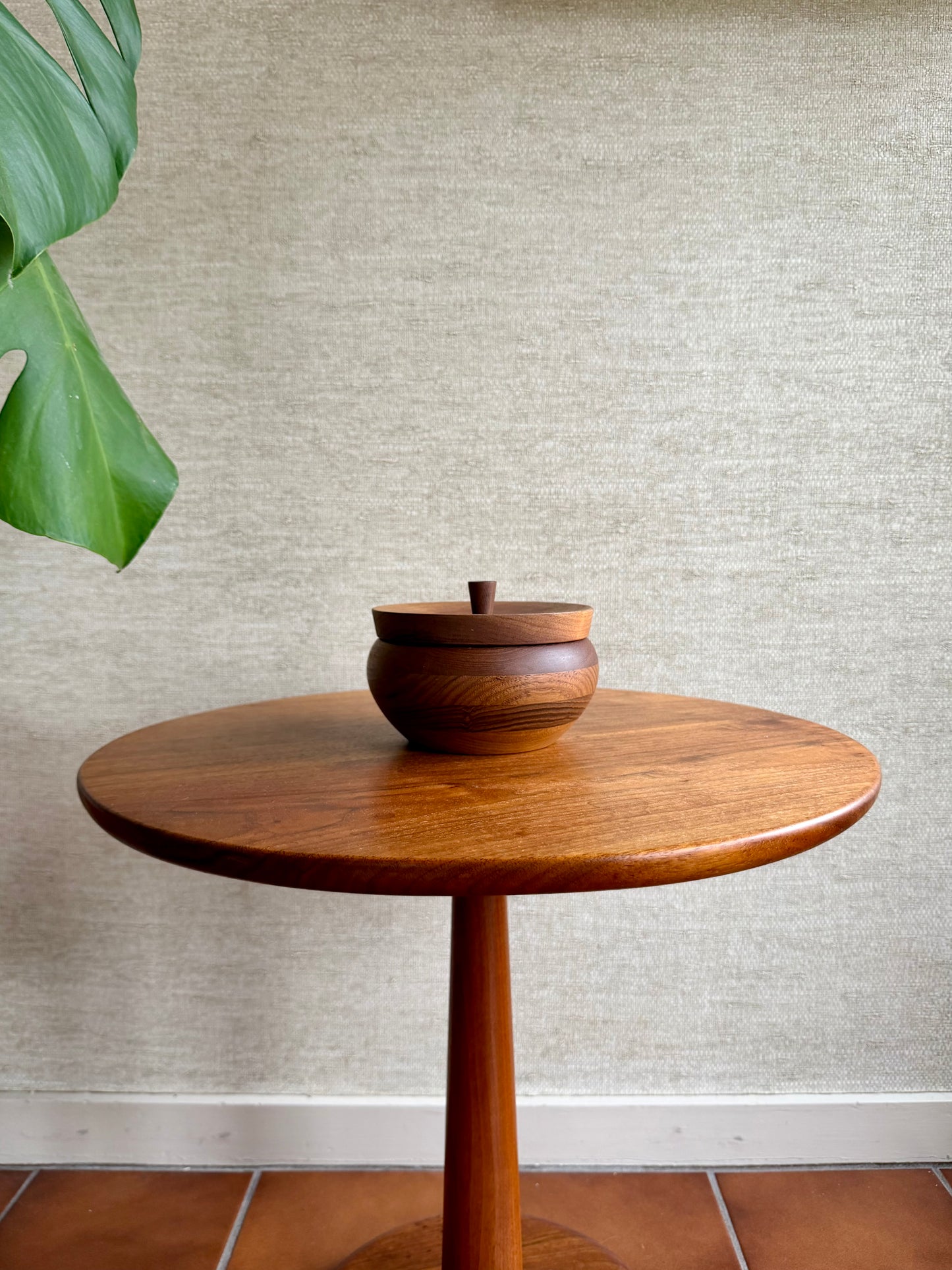 Wooden table with a bowl on a textured wall background