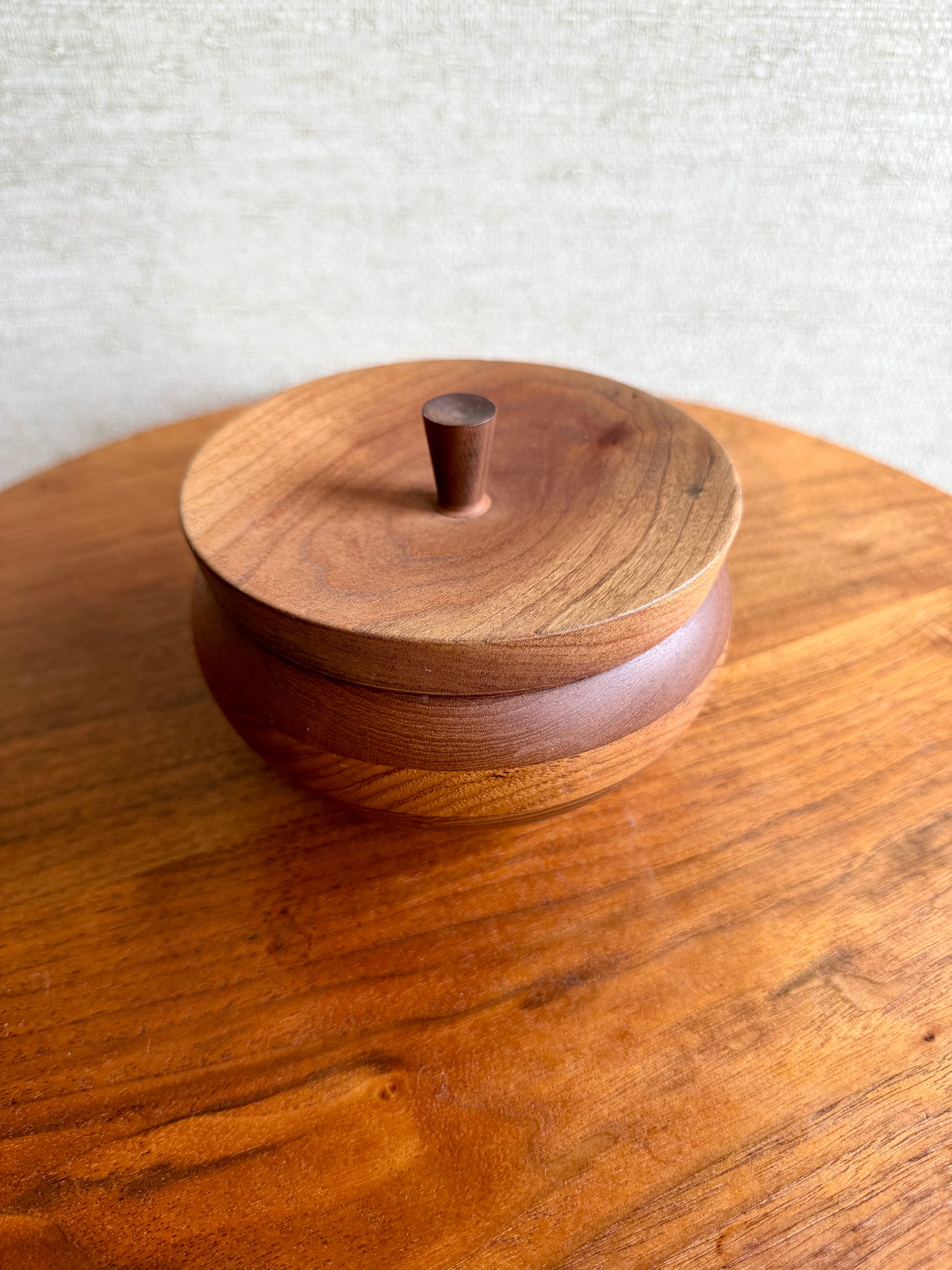 Wooden container with a lid on a wooden surface