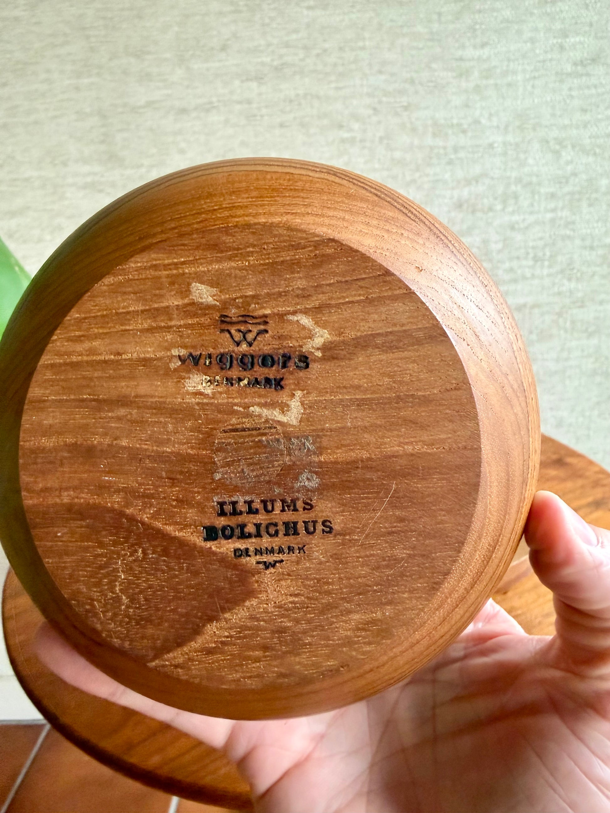 Wooden product with 'Illums Bolighus Denmark' branding held by a hand.
