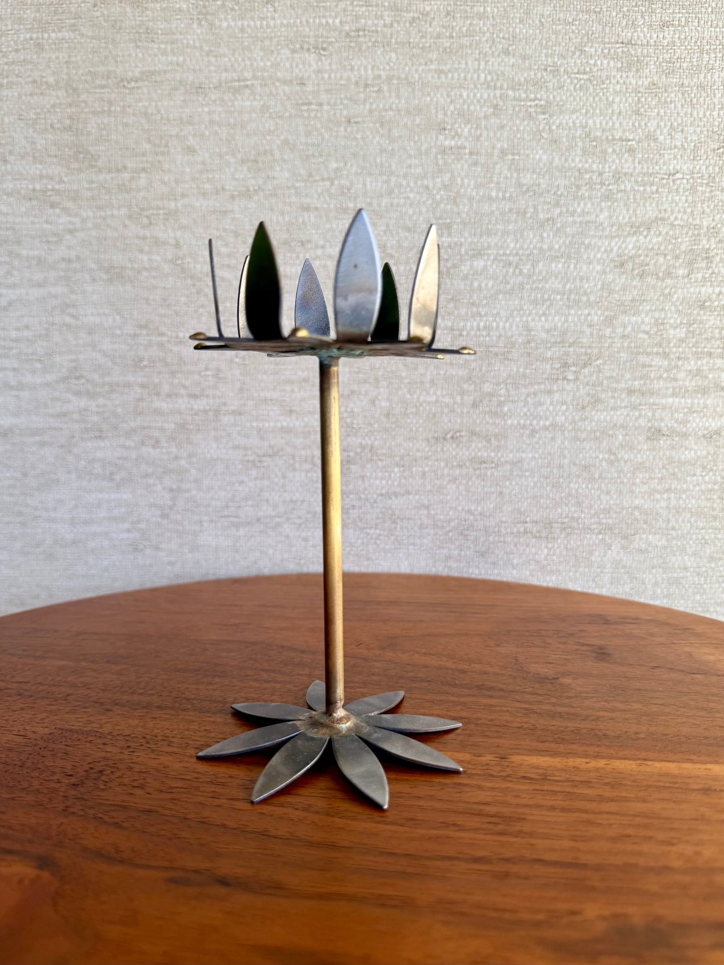 Decorative metal candle holder on a wooden surface with a neutral background