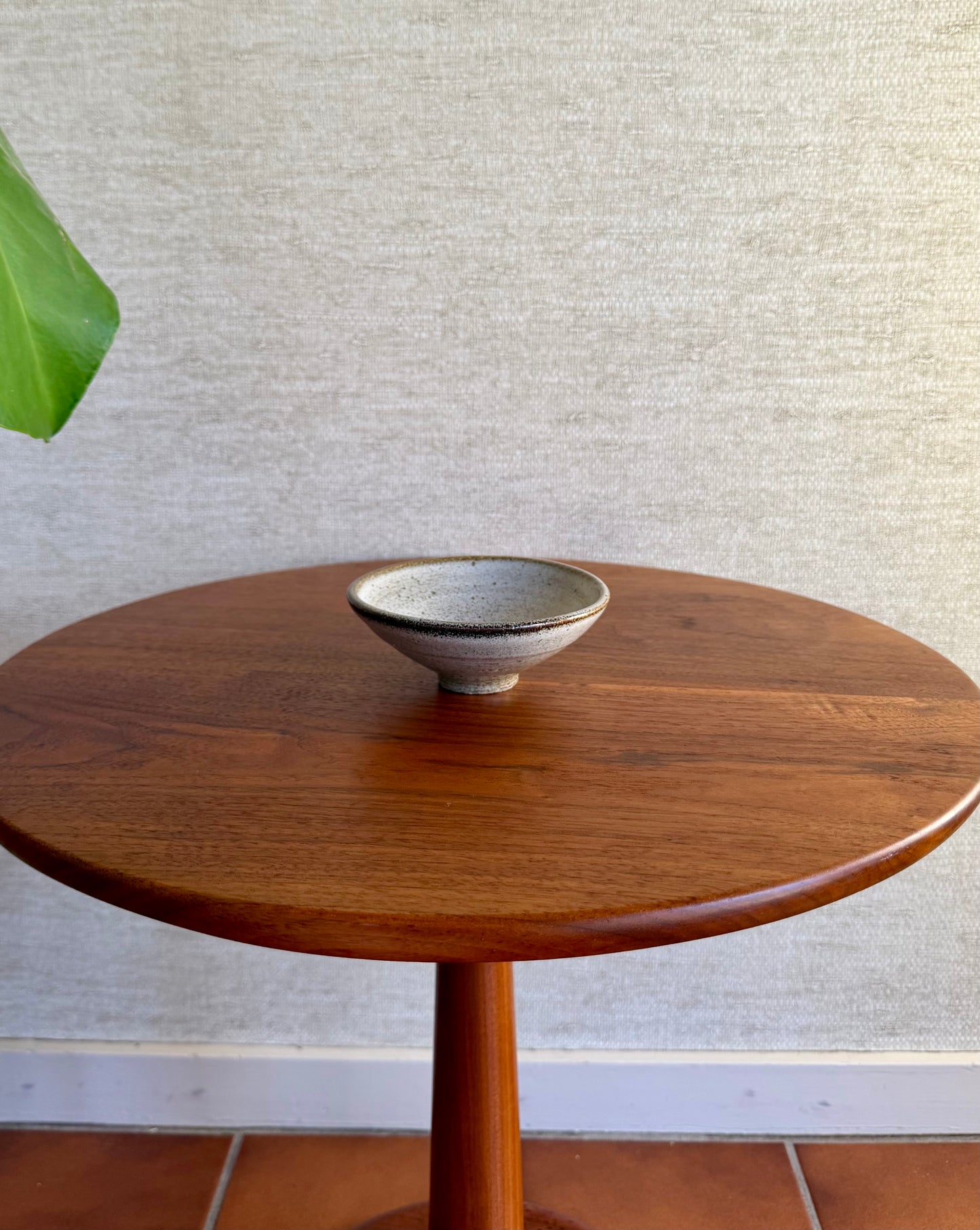 Wooden table with a ceramic bowl on a textured wall background