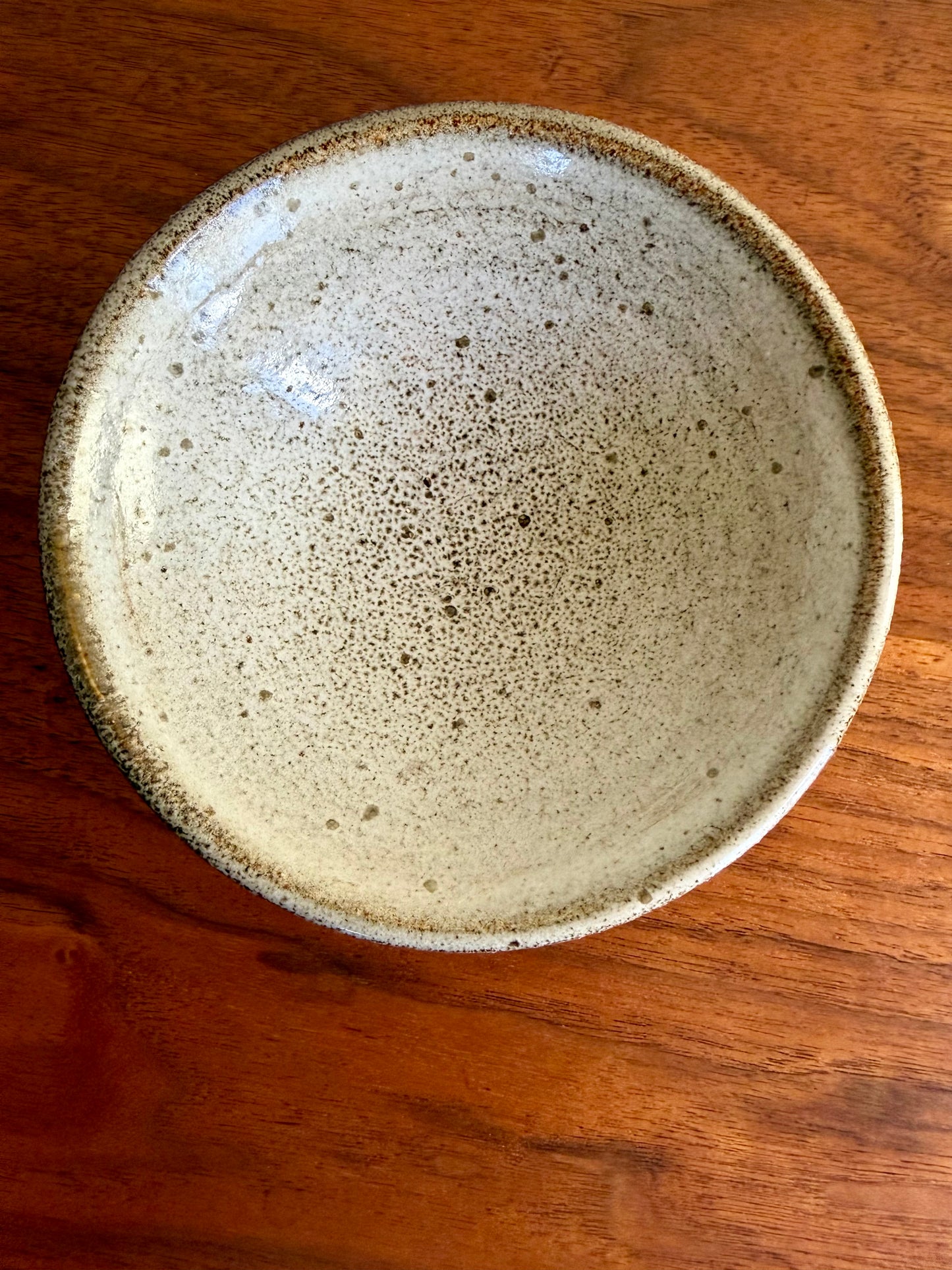 Ceramic bowl with speckled glaze on a wooden table