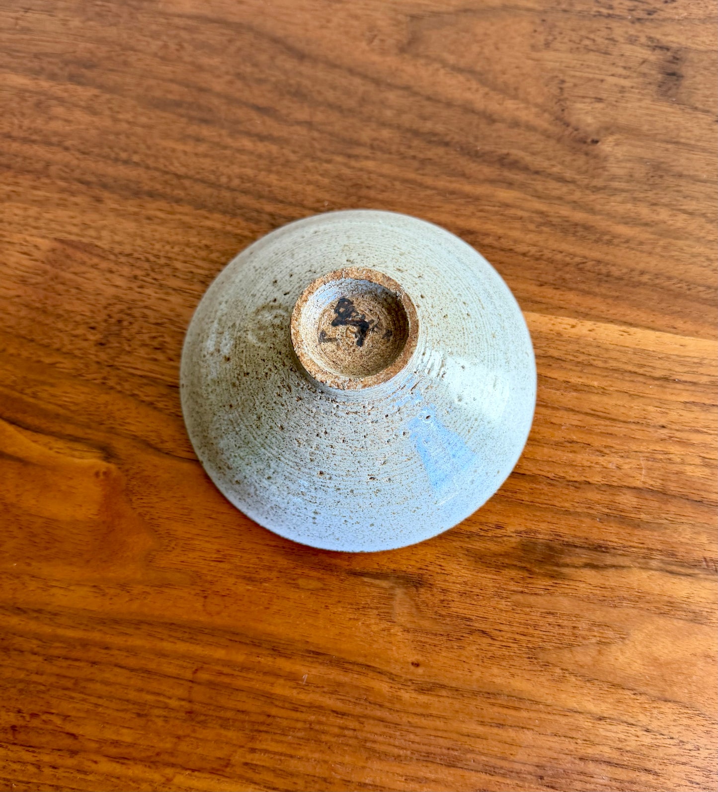 Bottom of a ceramic bowl on a wooden surface