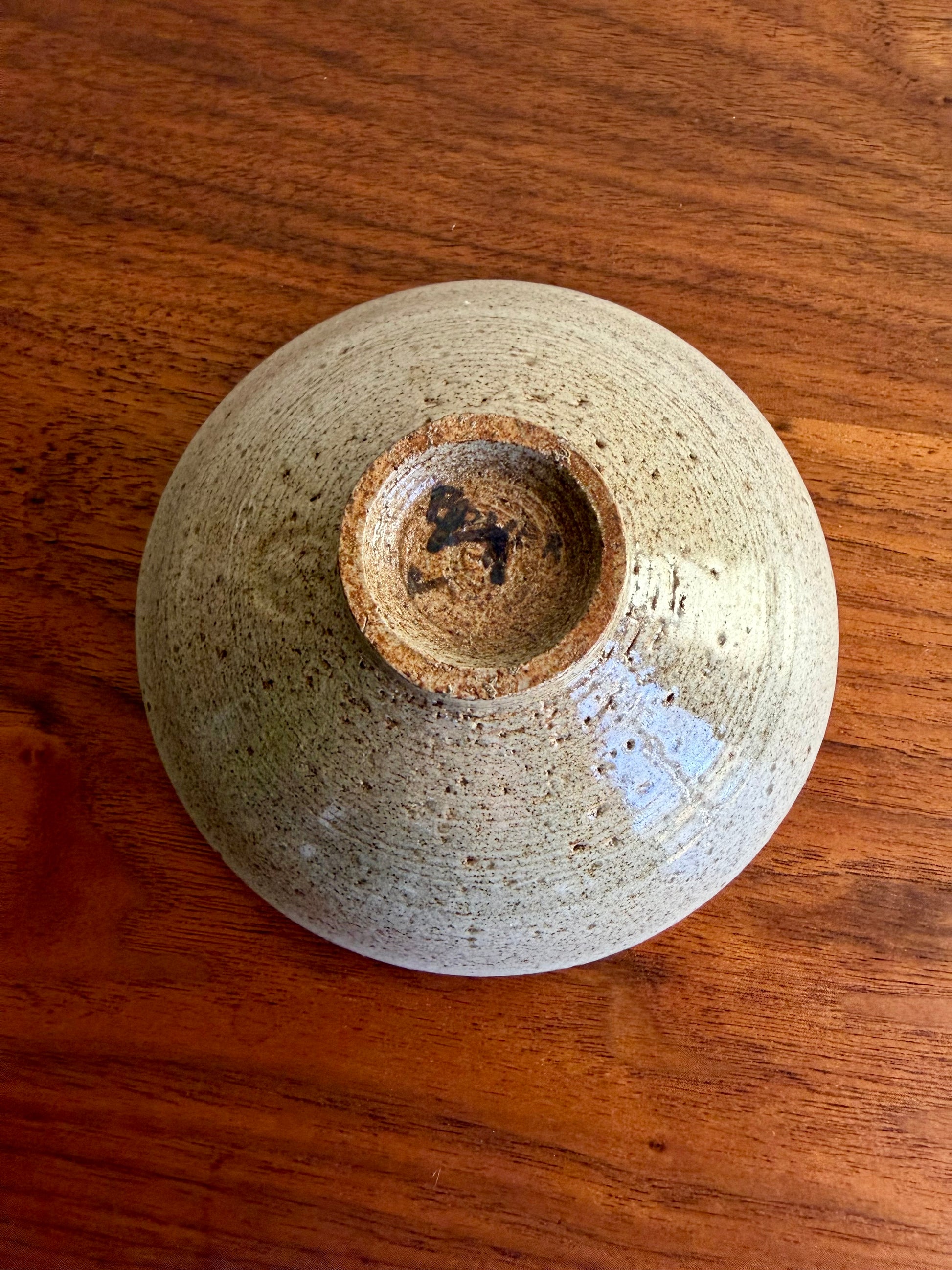 bottom of a ceramic bowl with a textured surface on a wooden table