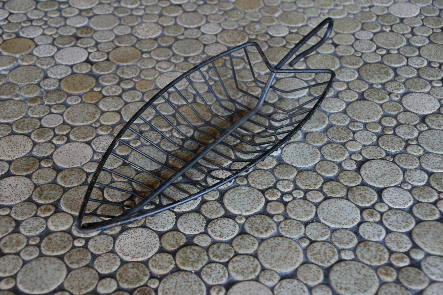 Black metal basket on a textured stone surface