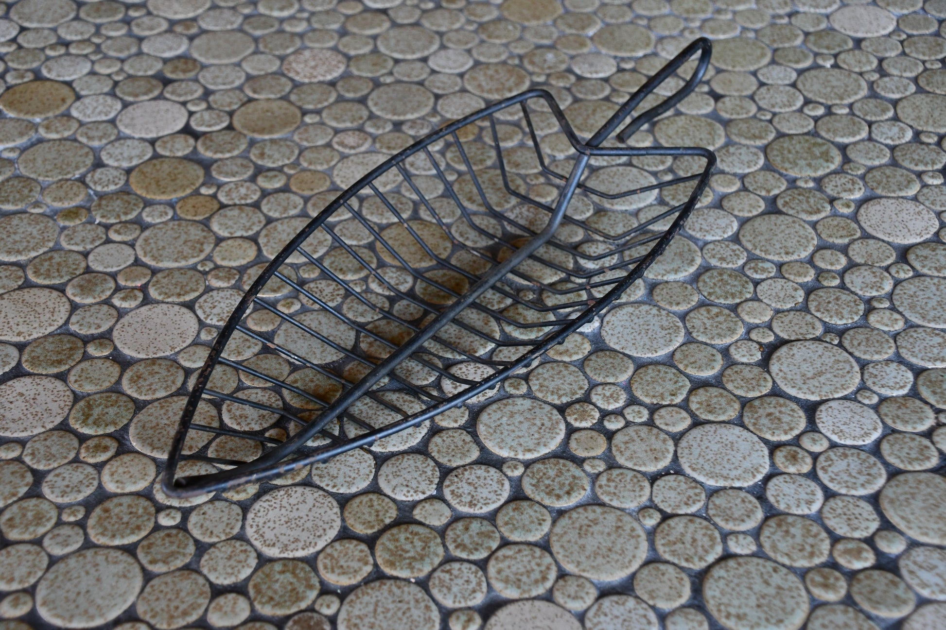 Black metal basket on a textured stone surface
