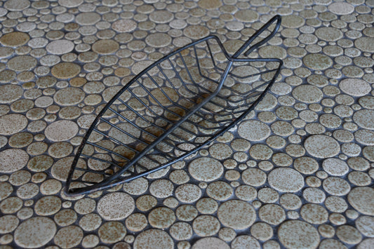Black metal basket on a textured stone surface