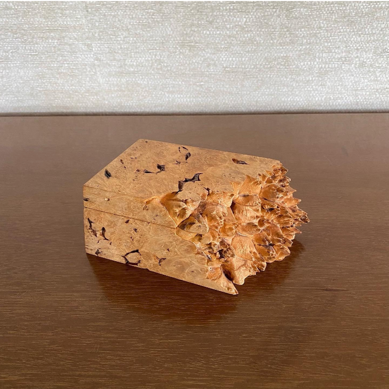 Wooden box with a textured surface on a reflective surface