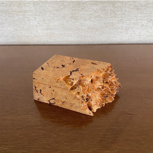Wooden box with a textured surface on a reflective surface