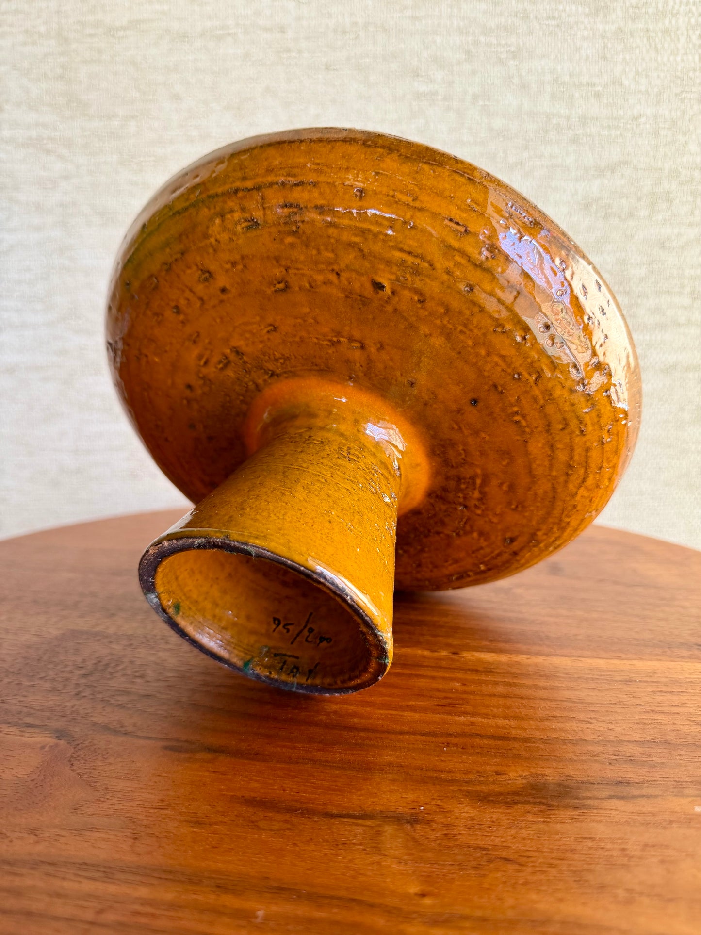 orange ceramic object on a wooden surface with a neutral background