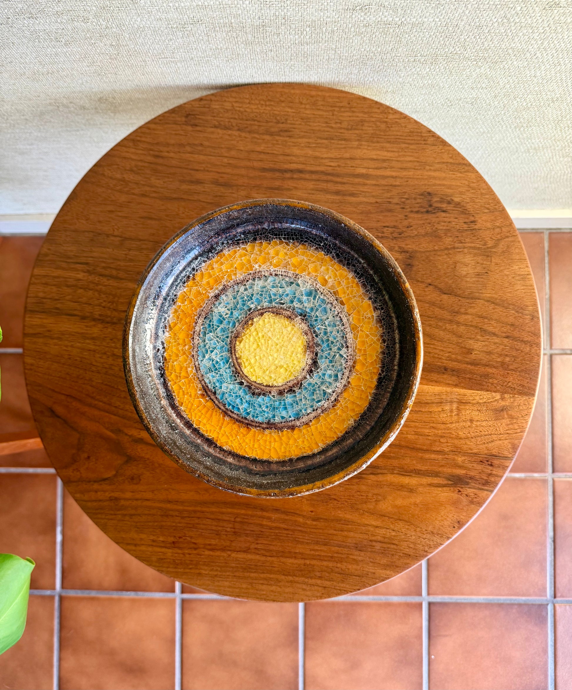 Decorative ceramic compote with concentric circle design on a wooden stand.