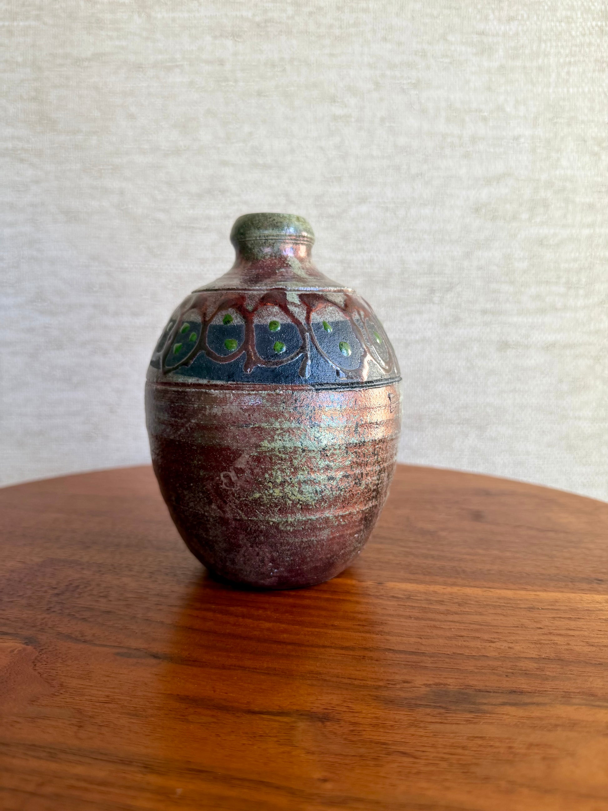 Ceramic vase with decorative lid on a wooden table