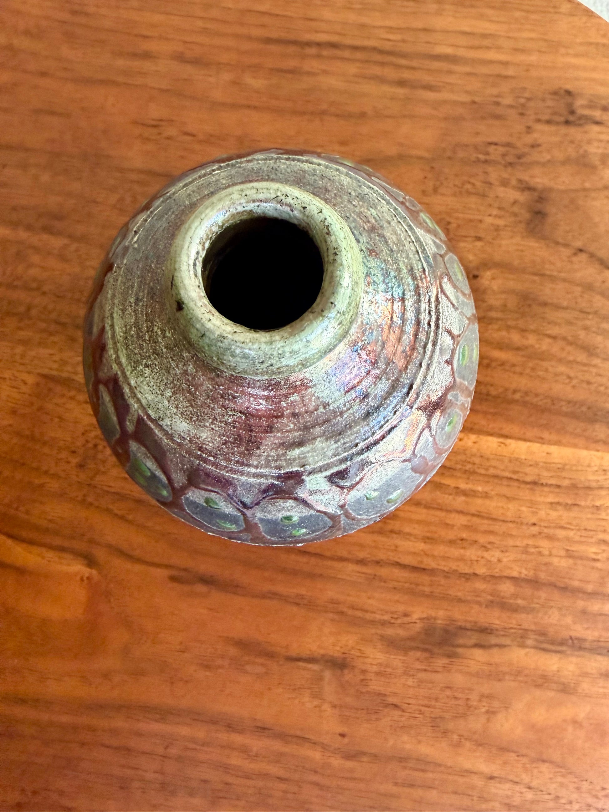 Ceramic vase with textured surface on a wooden surface