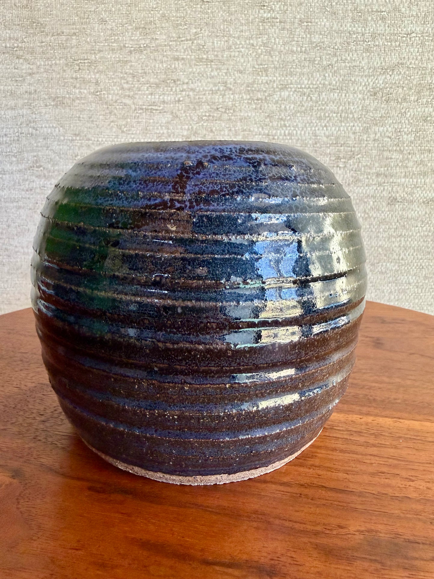 Decorative ceramic vase with striped pattern on a wooden surface