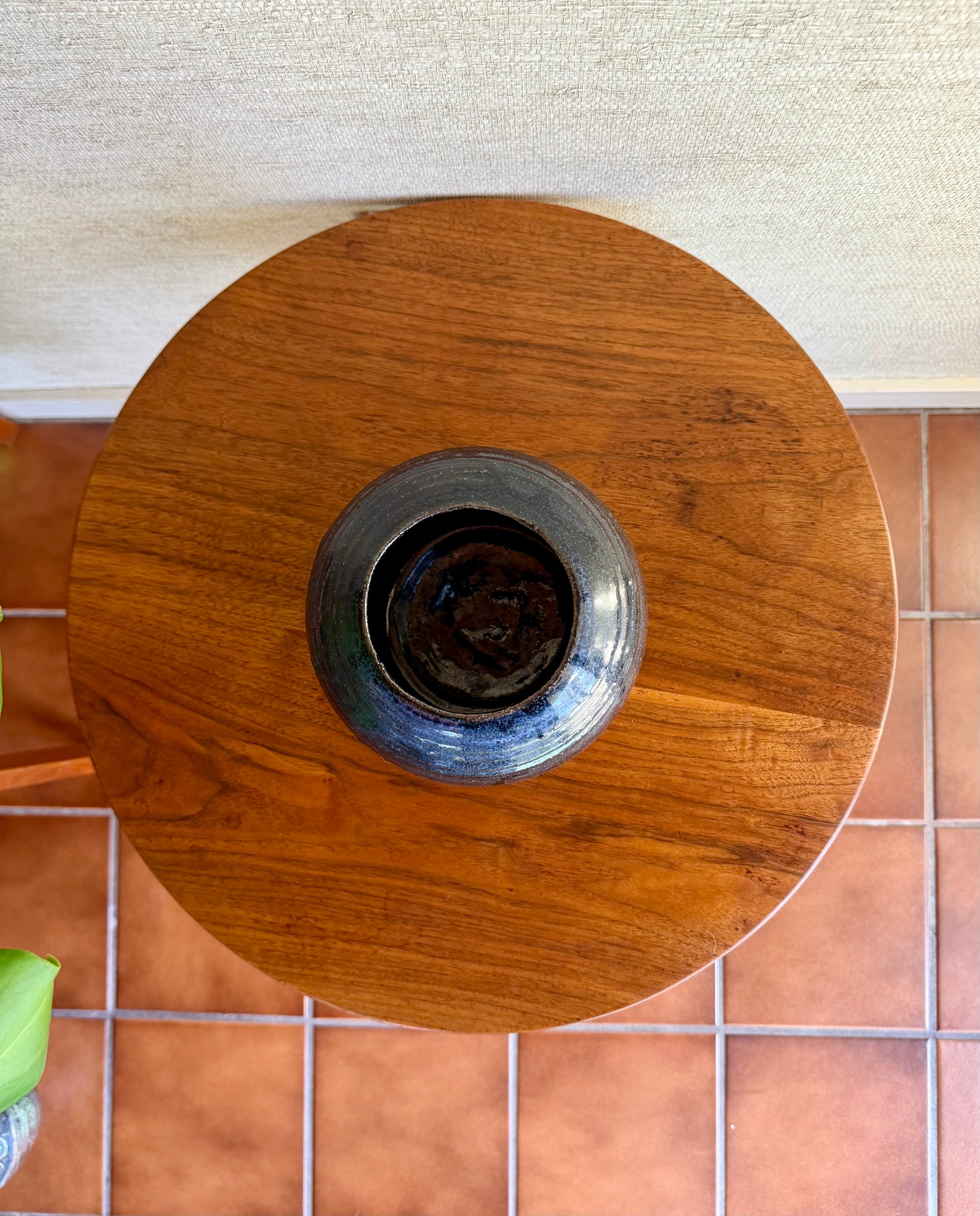 Wooden circular object with a metallic center on a tiled floor