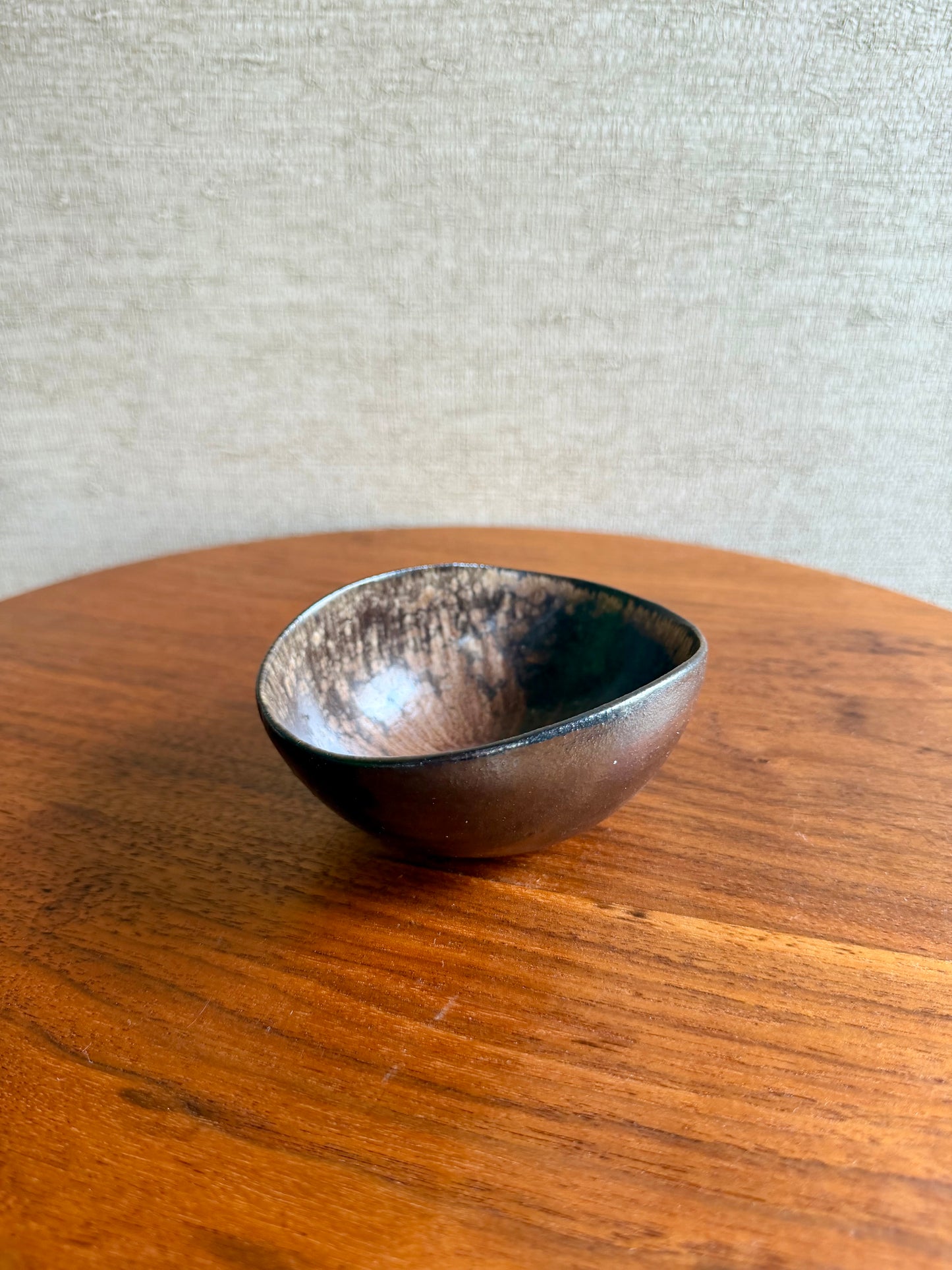 Small ceramic bowl on a wooden surface with a neutral background
