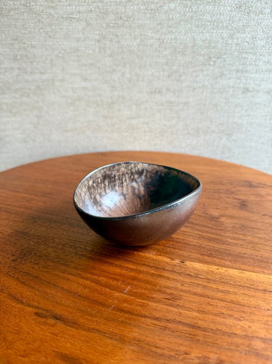 Small ceramic bowl on a wooden surface with a neutral background