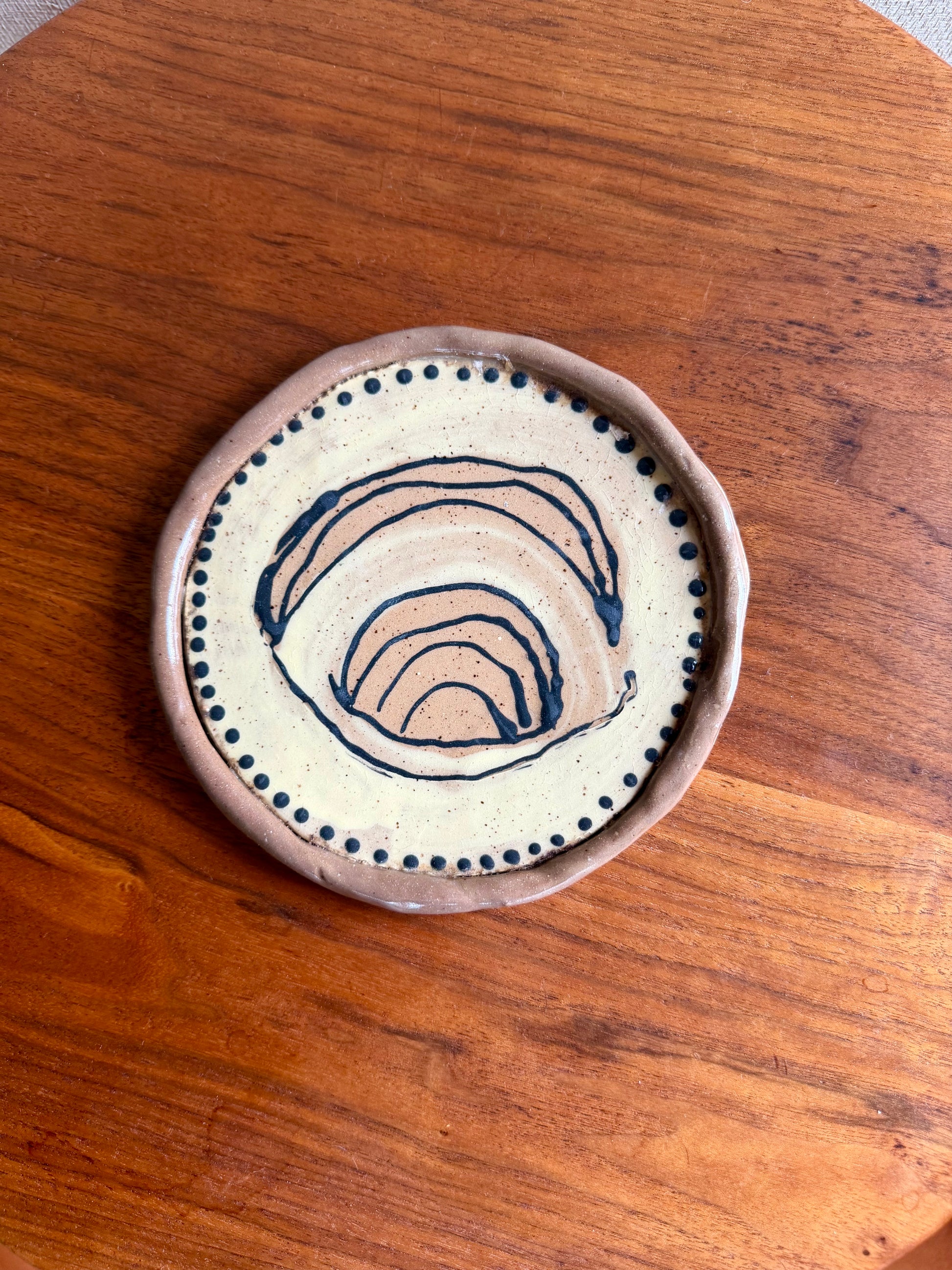 Ceramic plate with abstract design on a wooden surface