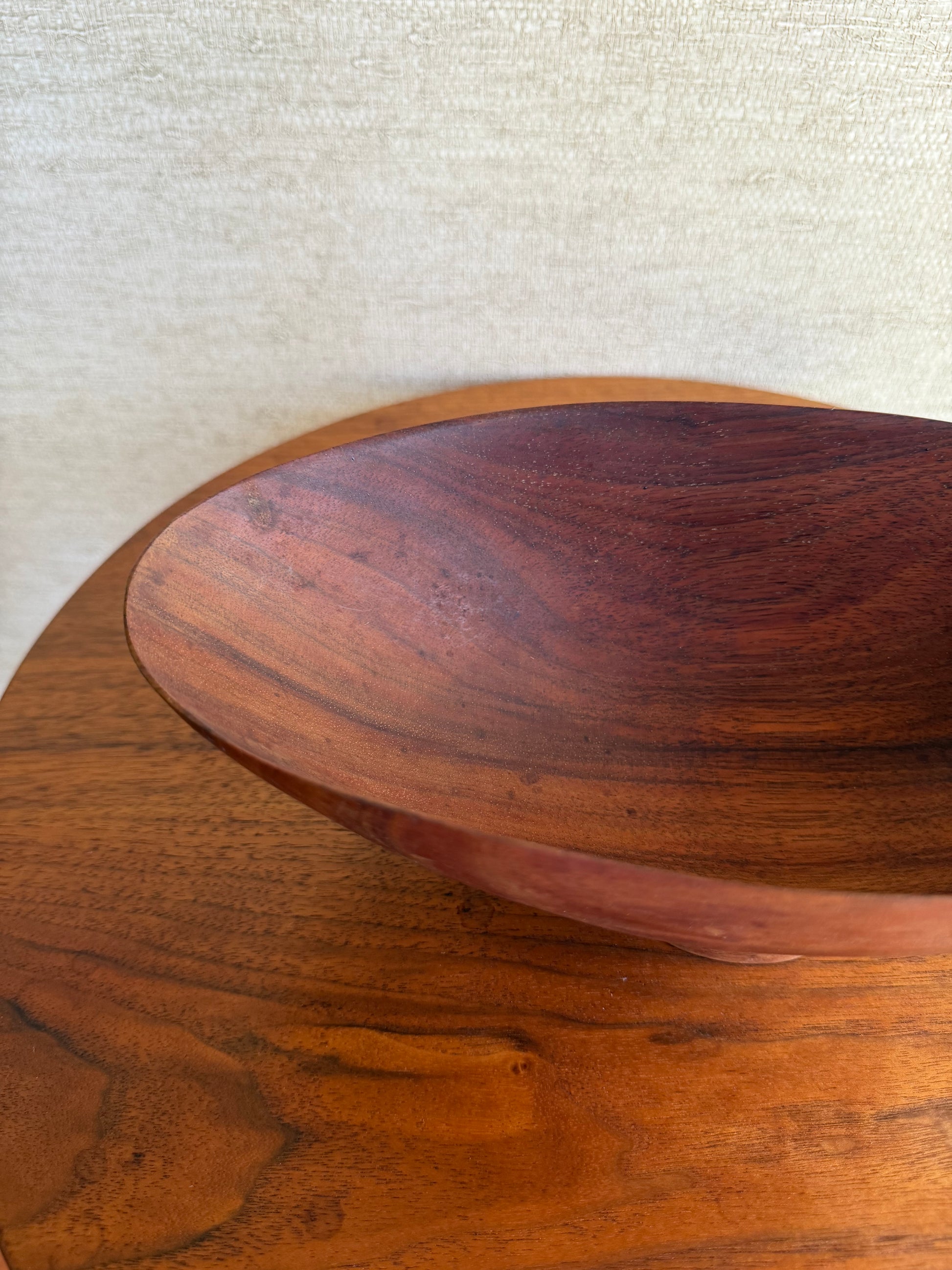 Close-up of a wooden bowl with a textured surface on a light fabric background