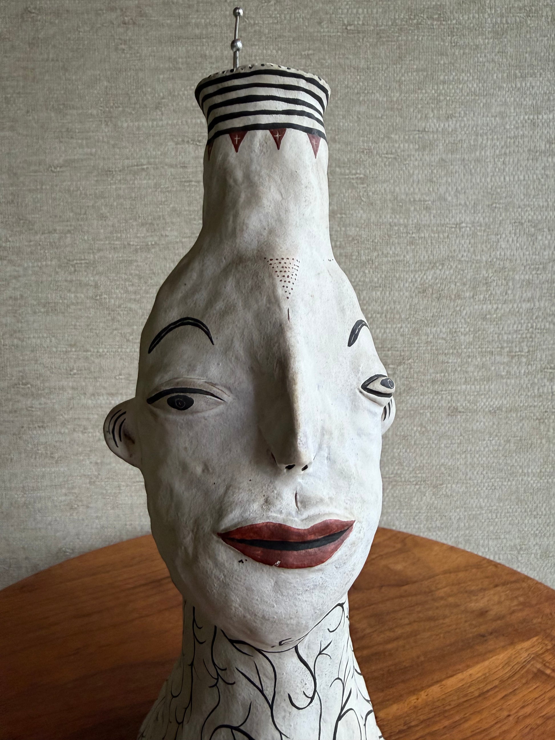 Decorative bust with artistic face details on a textured surface